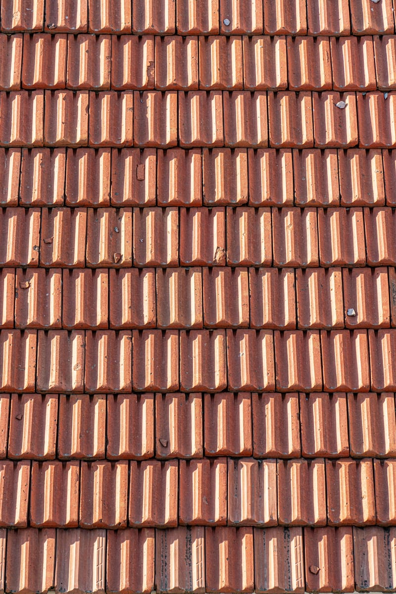 Close view of rows of weathered red clay roof tiles